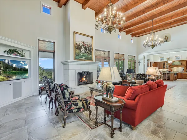 a living room with furniture a fireplace and a chandelier