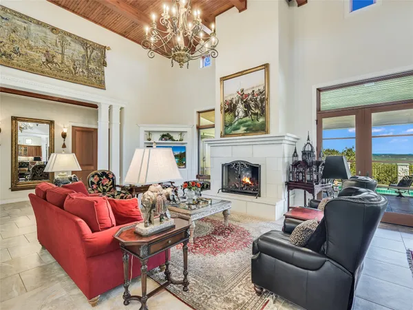 a living room with furniture chandelier and a fireplace