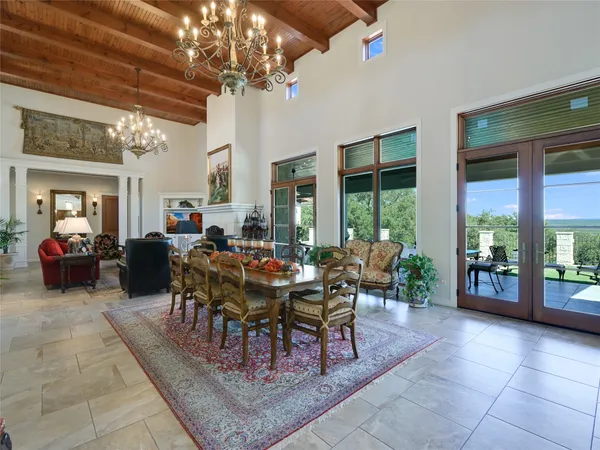 a living room with furniture a chandelier and a large window