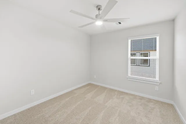 an empty room with a window and a fan