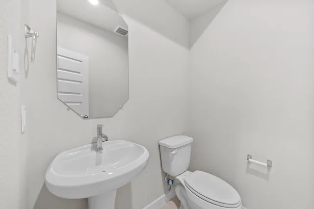 a bathroom with a sink a toilet and mirror
