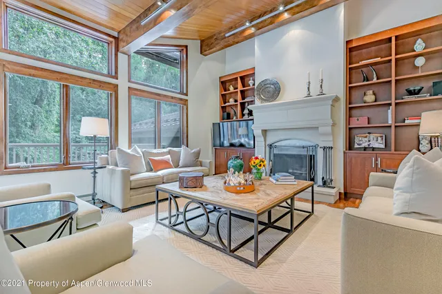a living room with fireplace furniture and a floor to ceiling window