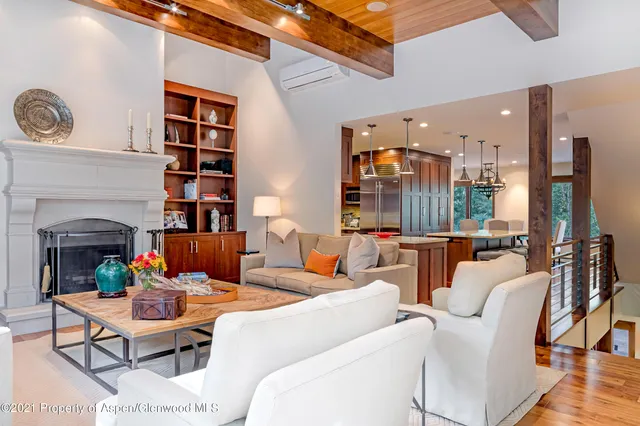 a living room with furniture a fireplace and a large window
