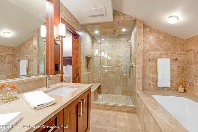 a bathroom with a granite countertop sink mirror and a bath tub