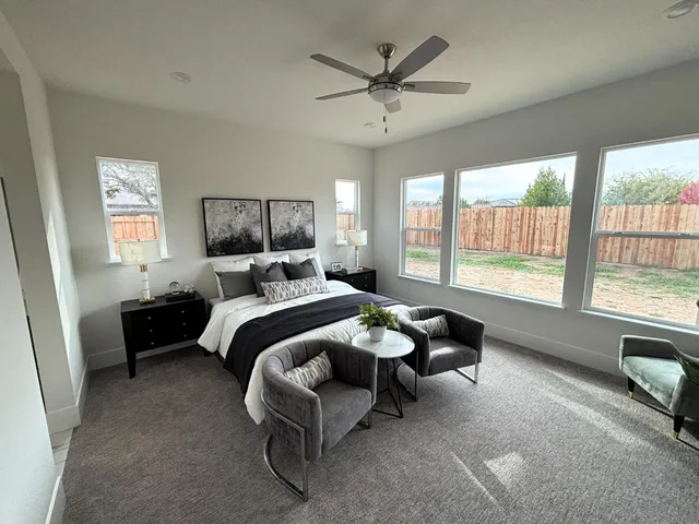 a spacious bedroom with a bed a couch and a large window