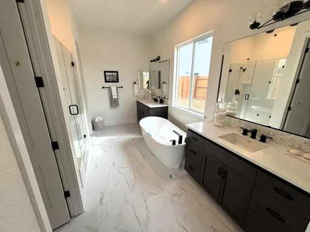 a spacious bathroom with a double vanity sink toilet mirror and window