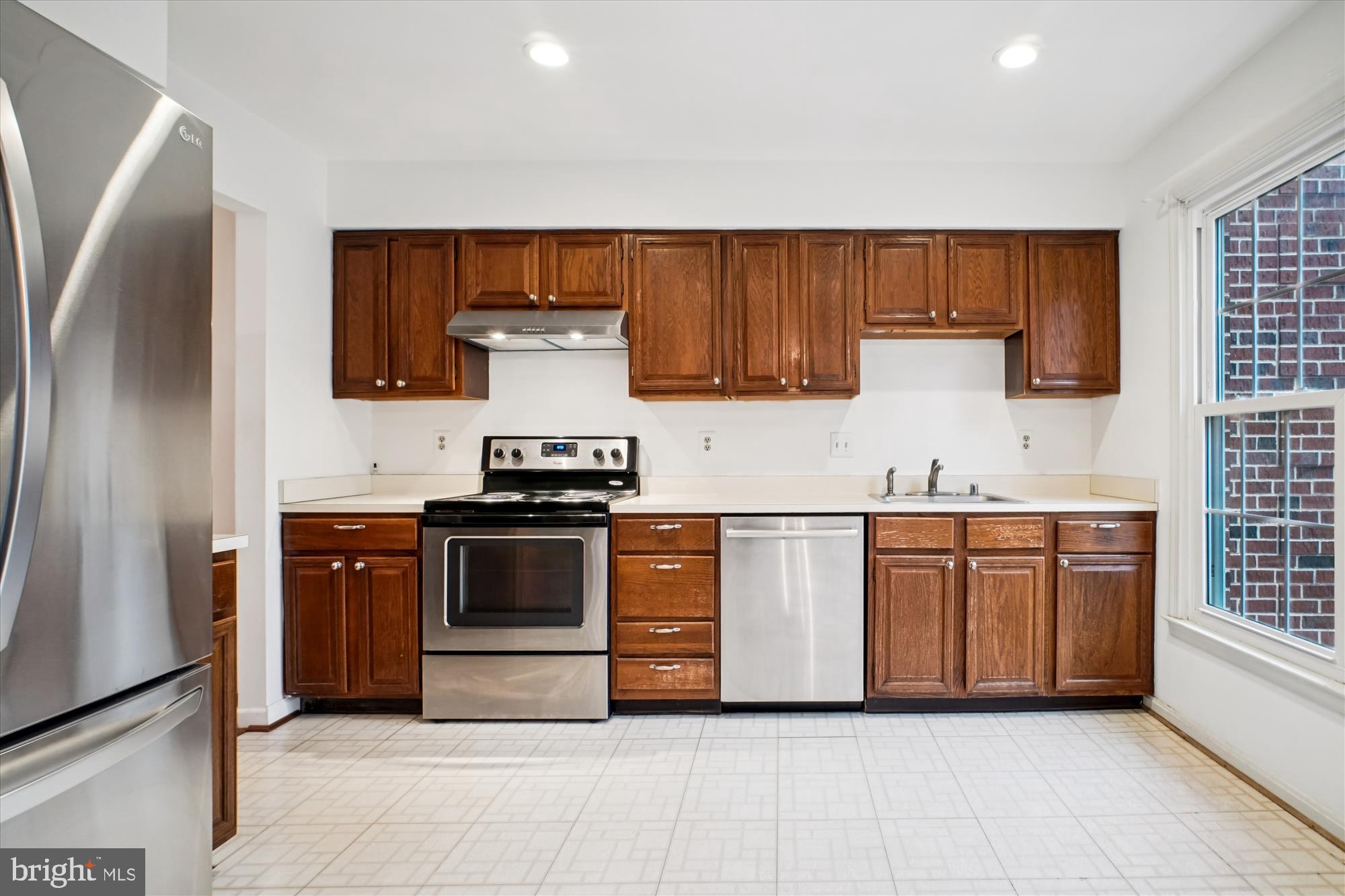 2816 Kelly Square Vienna, VA 22181 - Photo 14 of 73 a kitchen with stainless steel appliances granite countertop a stove a sink and a refrigerator