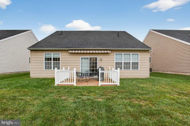 a backyard of a house with table and chairs