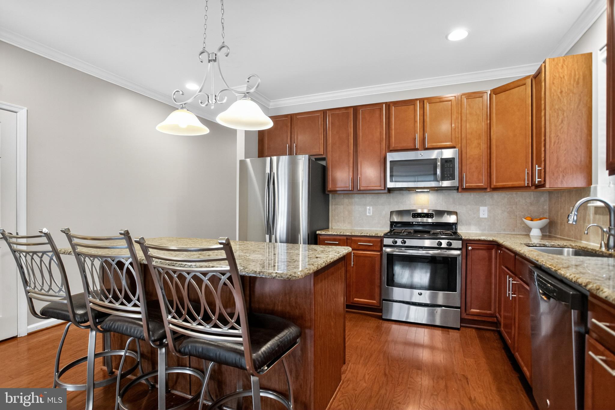 2680 Iris Lane Philadelphia, PA 19116 - Photo 9 of 30 a kitchen with stainless steel appliances granite countertop a stove top oven a refrigerator a sink dishwasher a dining table and chairs with wooden floor