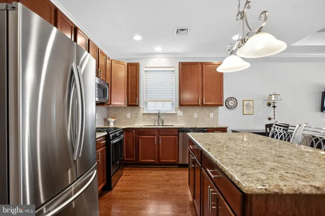 a kitchen with stainless steel appliances granite countertop a sink stove and refrigerator
