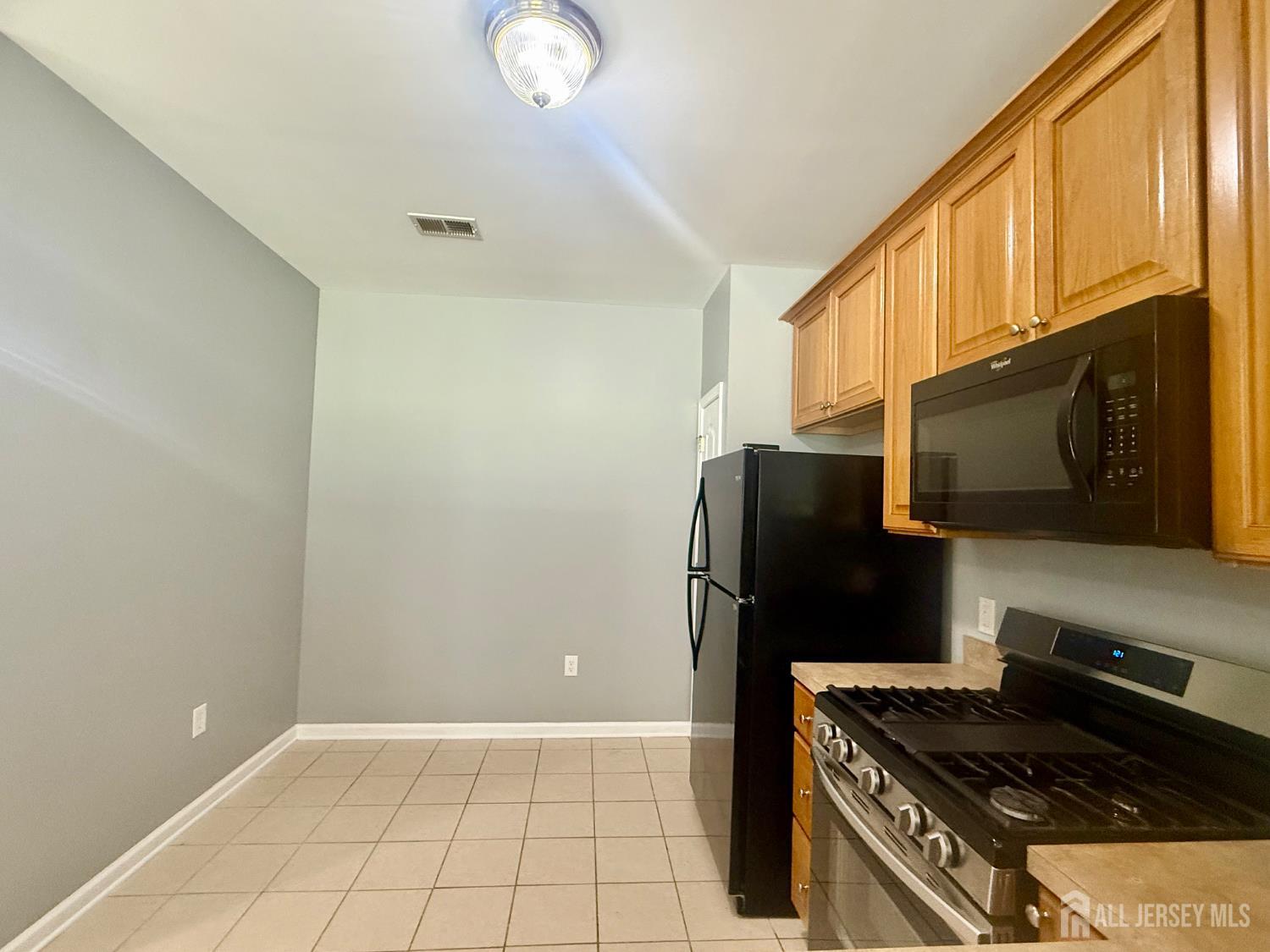 3213 Edward Stec Boulevard Edison, NJ 08837 - Photo 5 of 30 a kitchen with a refrigerator and a stove top oven