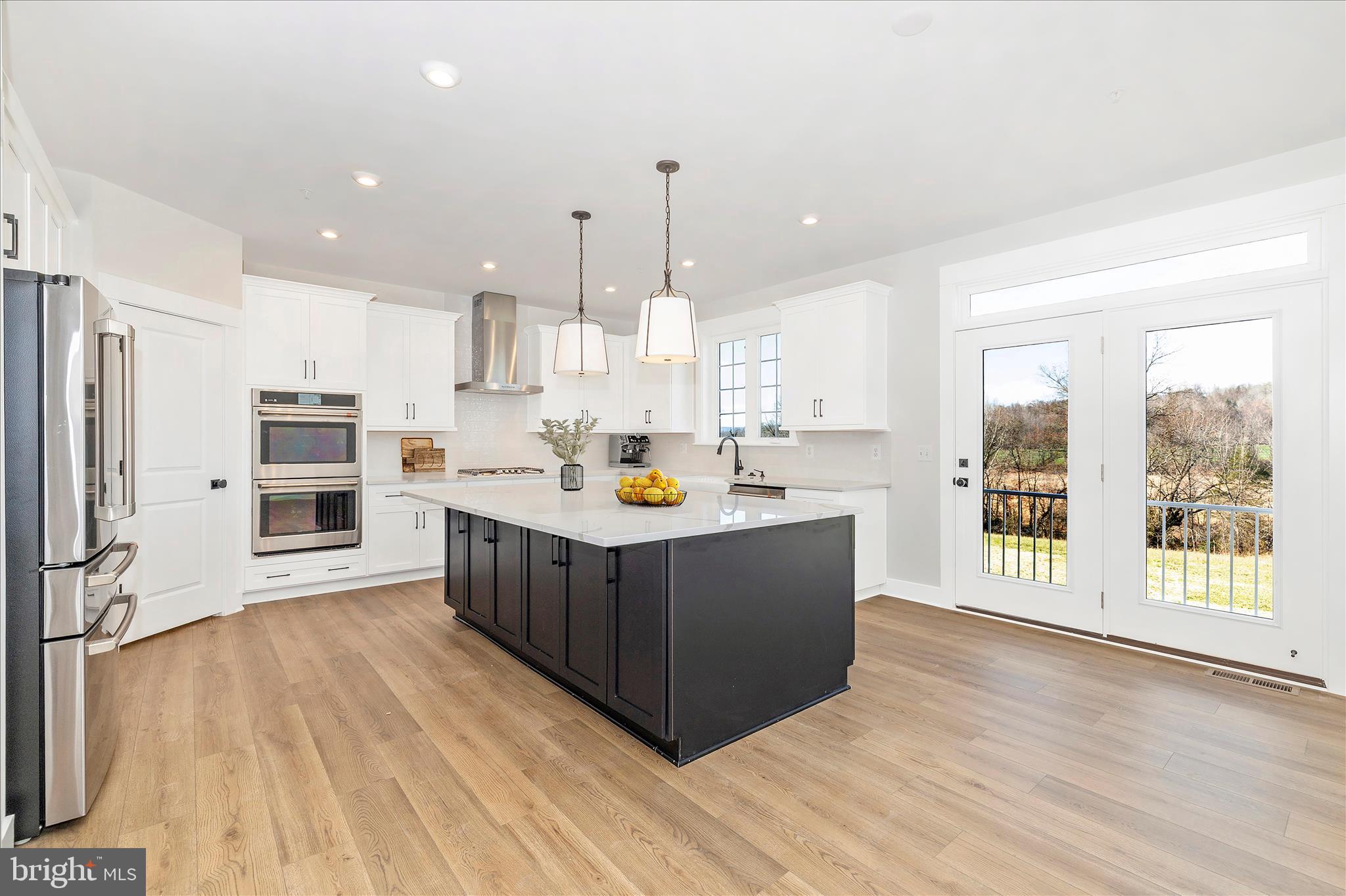 10242 Daysville Road Walkersville, MD 21793 - Photo 18 of 44 a large kitchen with stainless steel appliances granite countertop a large stove a refrigerator a sink and a oven with wooden floor