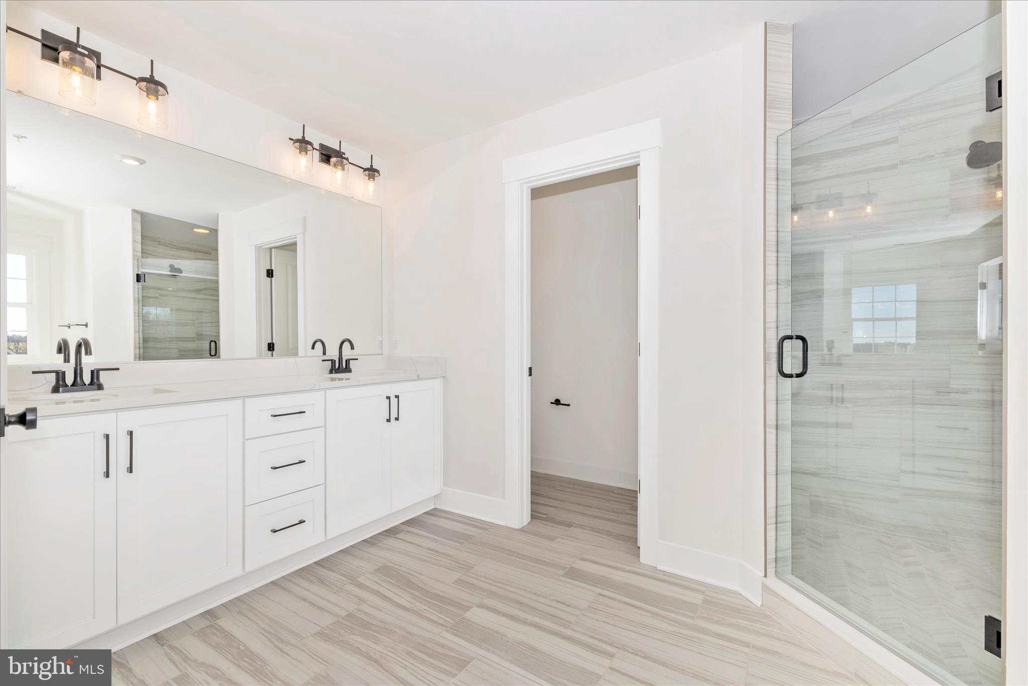 10242 Daysville Road Walkersville, MD 21793 - Photo 27 of 44 a spacious bathroom with double vanity a mirror and a shower