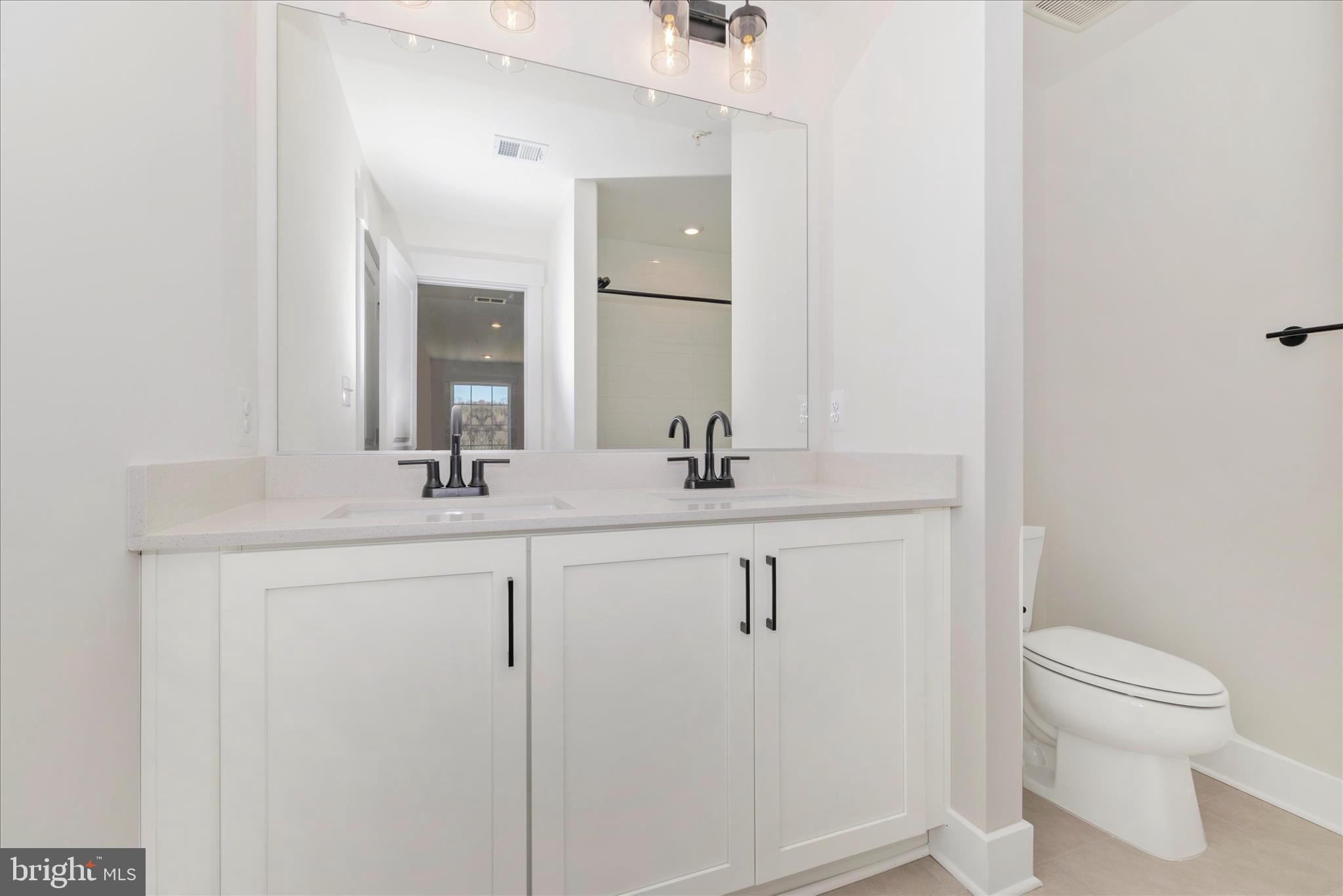 10242 Daysville Road Walkersville, MD 21793 - Photo 36 of 44 a bathroom with a toilet a sink a mirror and vanity