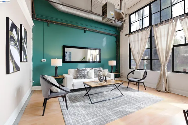 a living room with furniture and a painting on the wall