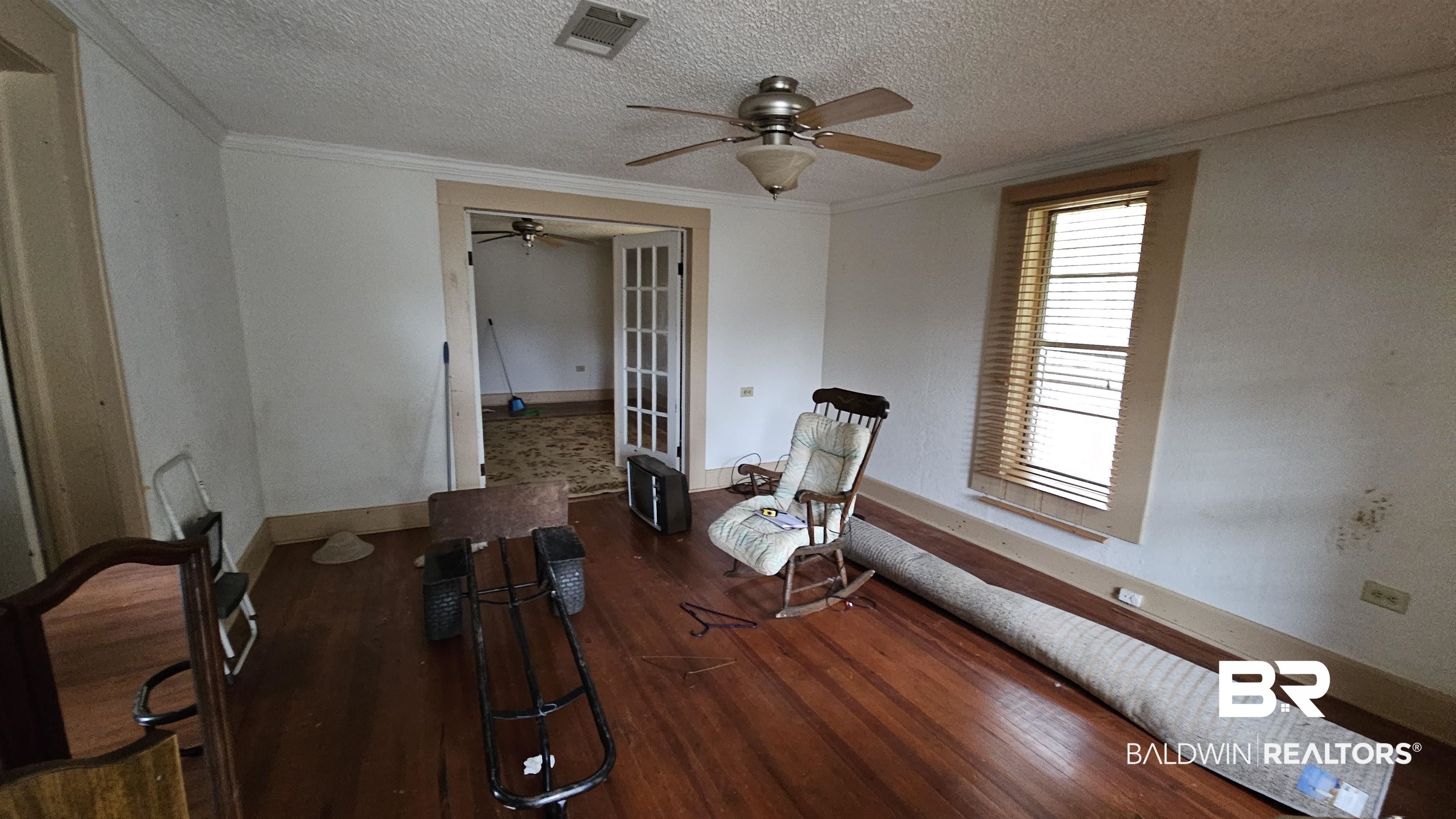 307 Scott Street Brewton, AL 36426 - Photo 3 of 19 Unfurnished room featuring ceiling fan, dark hardwood / wood-style flooring, crown molding, and a textured ceiling