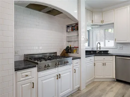 a kitchen with stainless steel appliances granite countertop a sink and cabinets