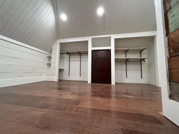 a view of a closet with wooden floor