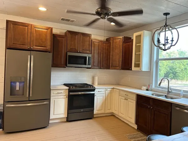 a kitchen with a refrigerator window and wooden cabinets