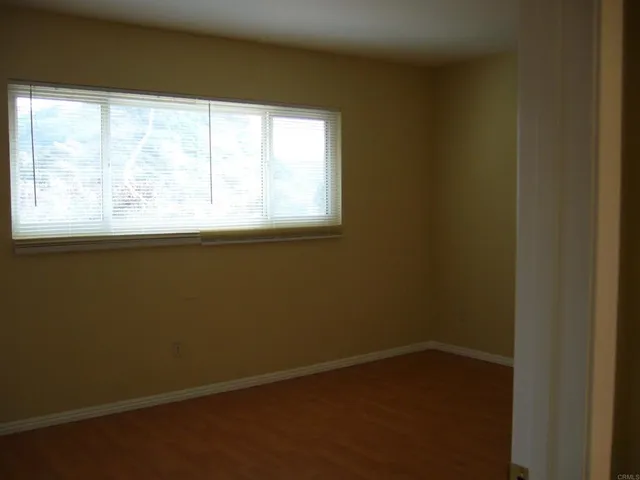 a view of a small space with wooden floor and a window