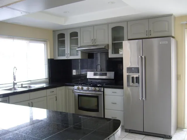 a kitchen with stainless steel appliances granite countertop a stove a refrigerator and a sink