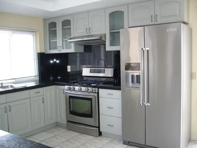 a kitchen with stainless steel appliances granite countertop a refrigerator stove and sink