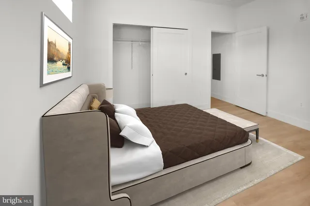 a bedroom with a bed and painting on the wall