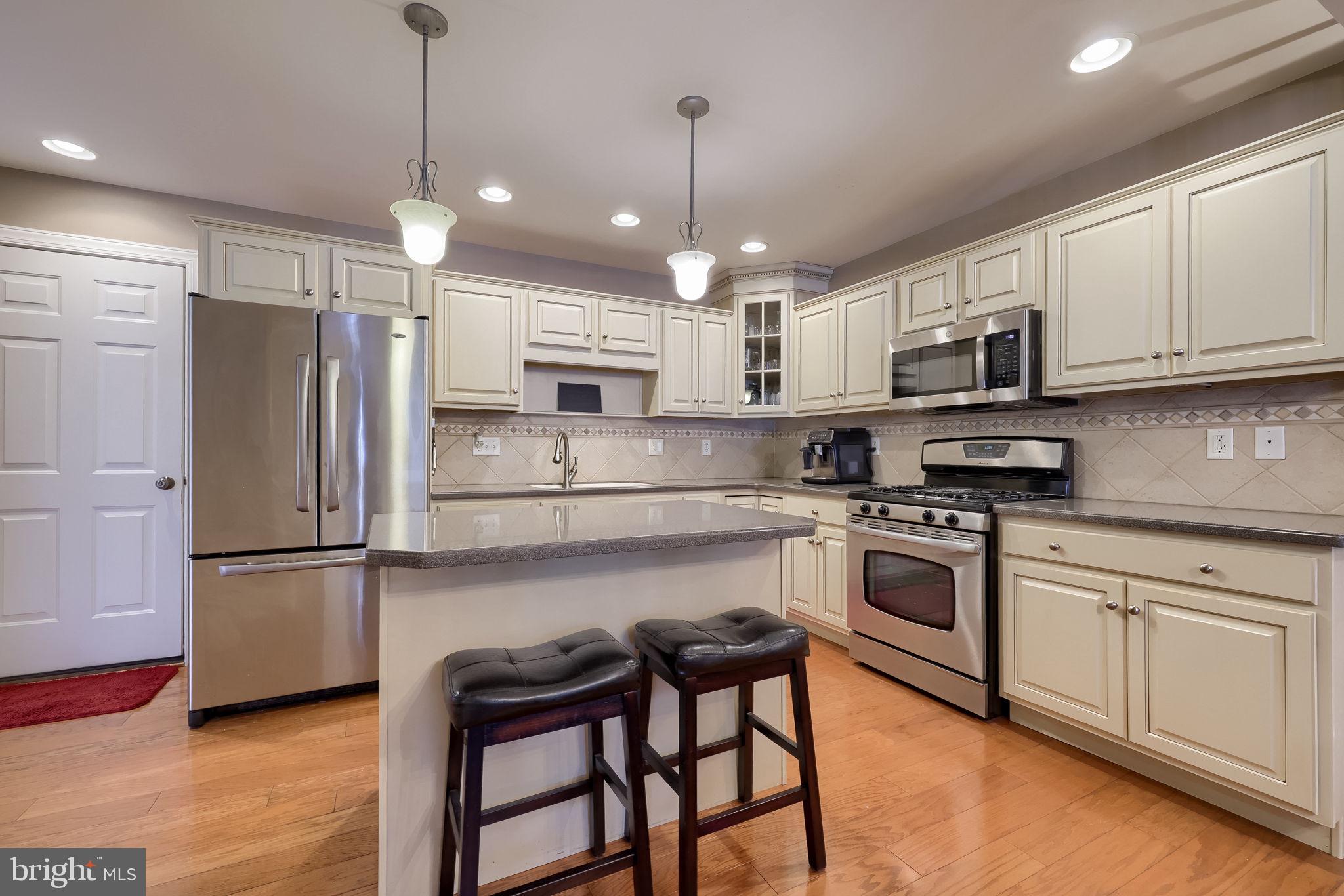 147 Fieldcrest Lane Ephrata, PA 17522 - Photo 9 of 47 a kitchen with stainless steel appliances granite countertop a refrigerator a sink dishwasher a stove and white cabinets with wooden floor