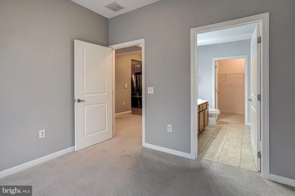 an empty room and a bathroom with a sink
