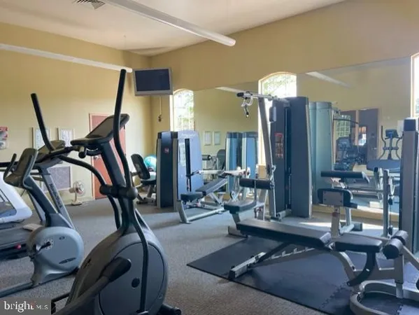 a living room with furniture a floor to ceiling window and gym equipment