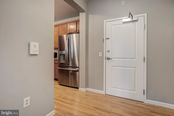a view of kitchen and empty room with wooden floor