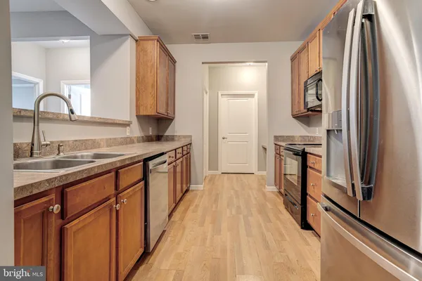 a kitchen with stainless steel appliances granite countertop a refrigerator and a sink