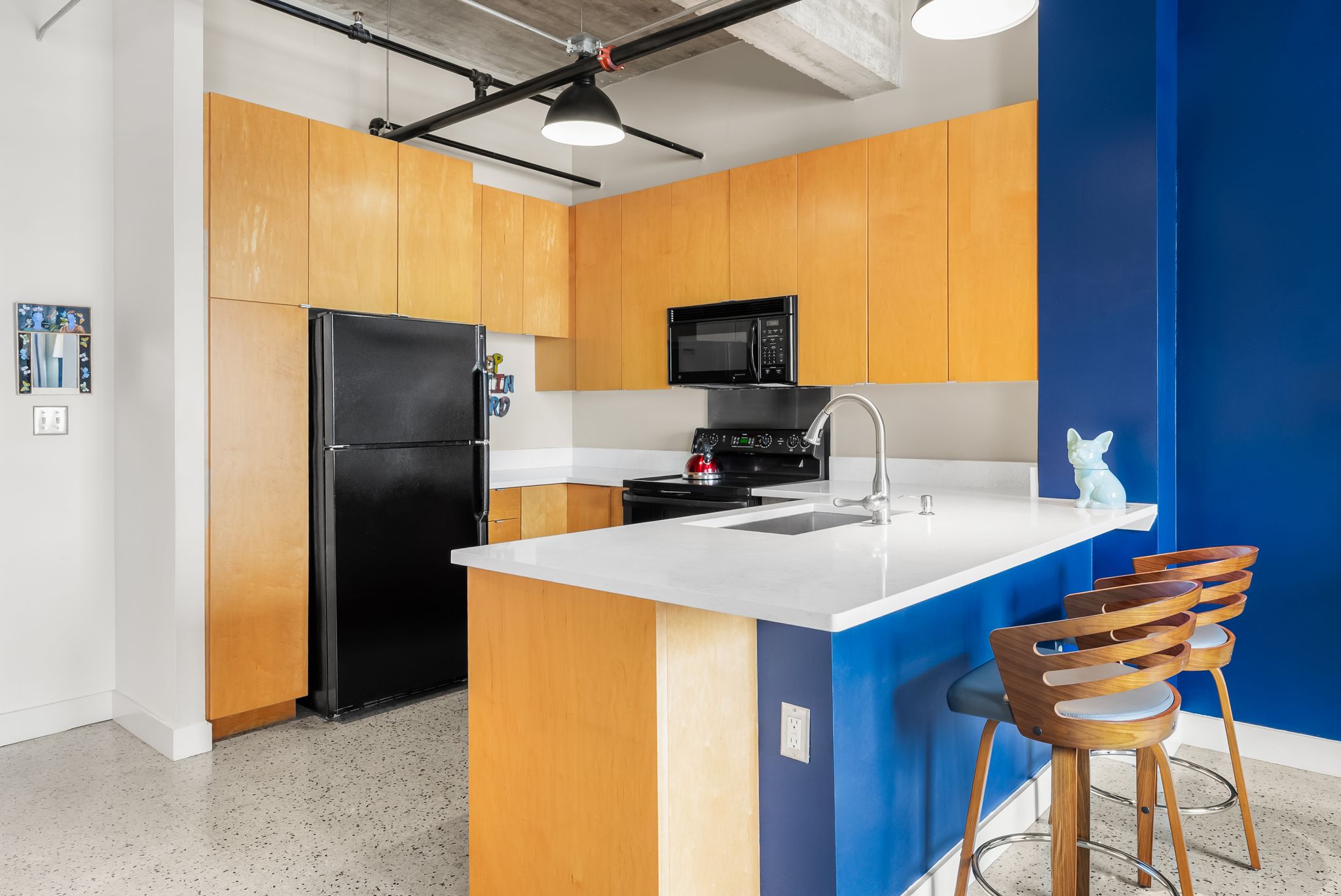 710 Colorado Street, Unit 6E Austin, TX 78701 - Photo 4 of 24 A vibrant kitchen features an island with bar seating and light wood cabinetry.