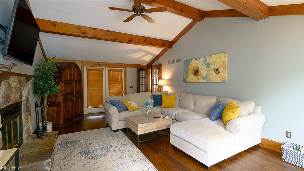 301 Perry Drive Northwest Canton, OH 44708 - Photo 22 of 34 Hardwood floored living room with lofted ceiling with beams, ceiling fan, and a stone fireplace
