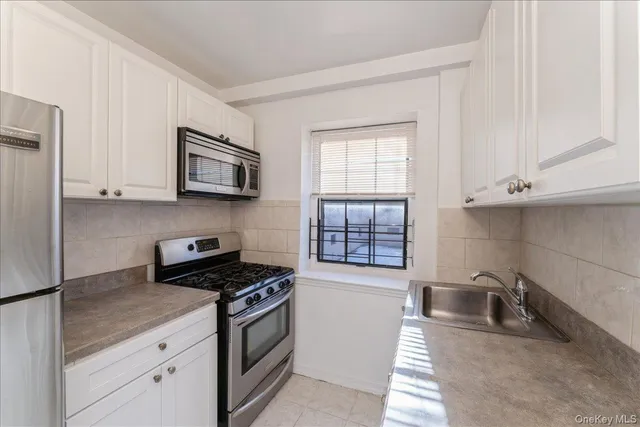 a kitchen with stainless steel appliances a sink stove and microwave