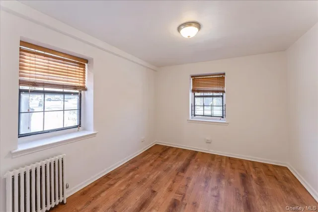 an empty room with a window and wooden floor
