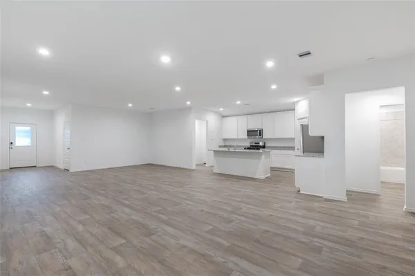 a view of kitchen with kitchen island microwave and stove top oven