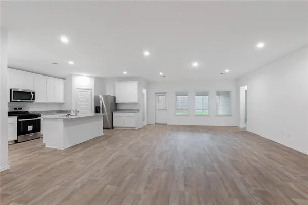 a view of kitchen with wooden floor and electronic appliances