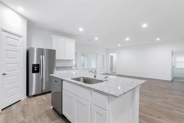 a kitchen with stainless steel appliances granite countertop a sink and a refrigerator