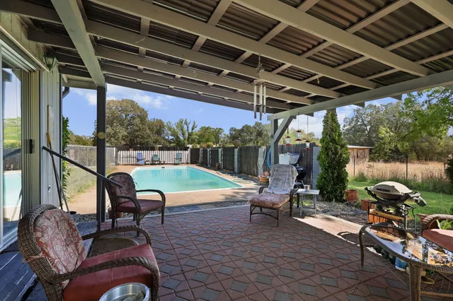 a view of a porch with furniture and a yard