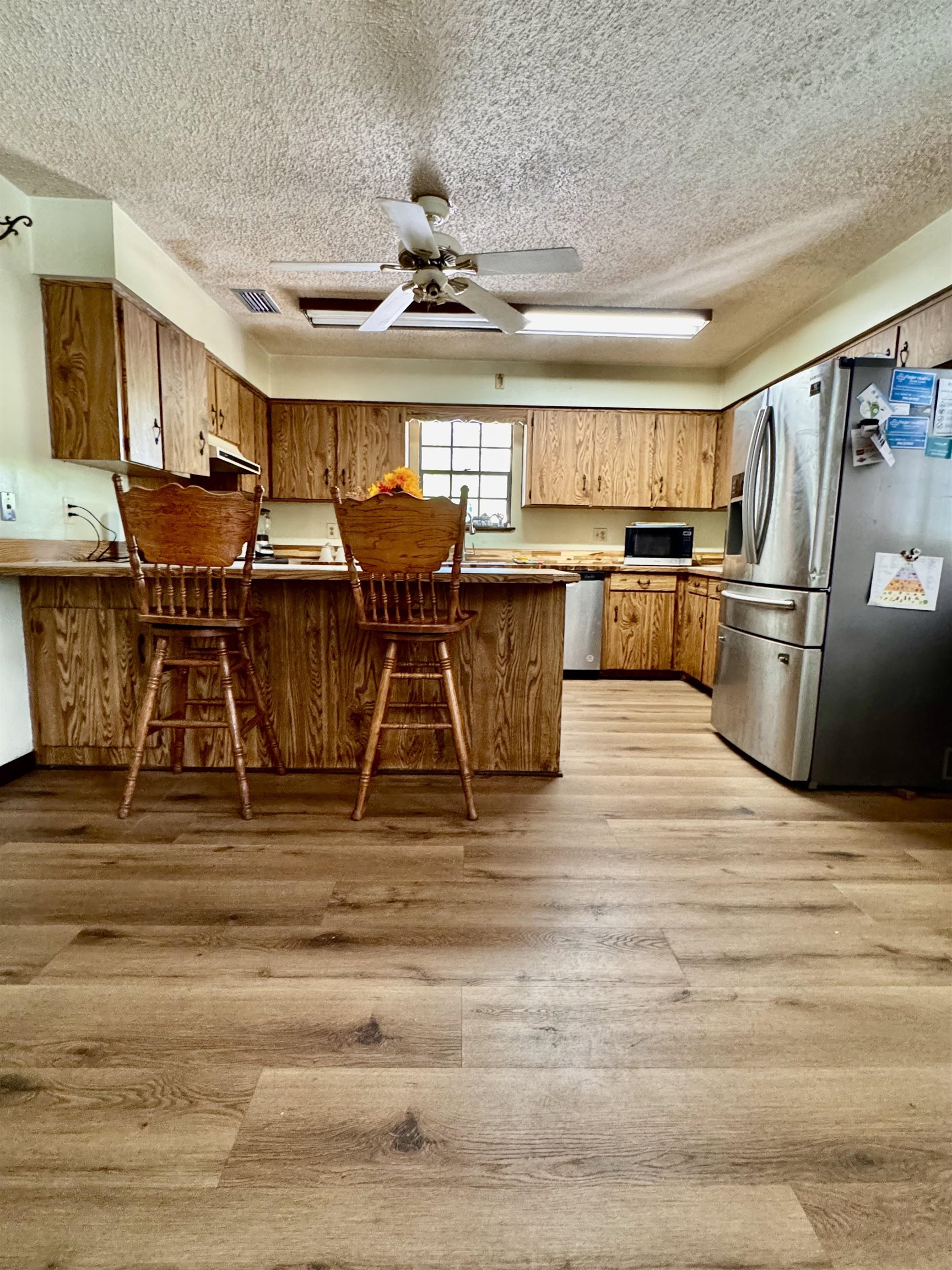 554 Hayley Road St. Augustine, FL 32086 - Photo 17 of 46 a living room with stainless steel appliances kitchen island granite countertop a table chairs and a wooden floor