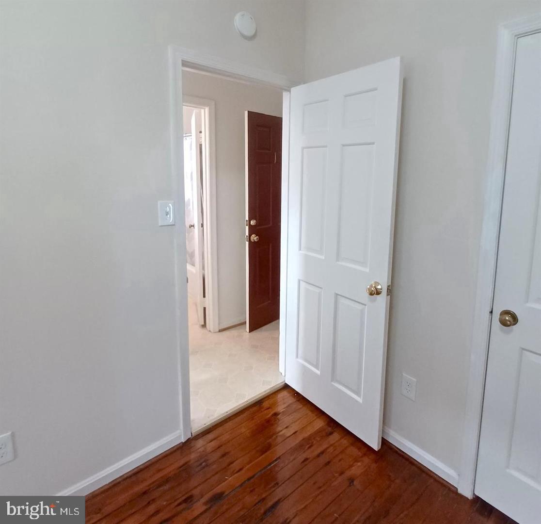 301 North West Street, Unit 1 Alexandria, VA 22314 - Photo 6 of 16 an empty room with wooden floor & closet area