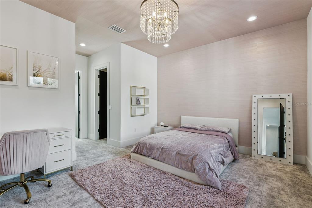 15746 Pendio Drive Montverde, FL 34756 - Photo 36 of 71 a bedroom with a bed and a chandelier