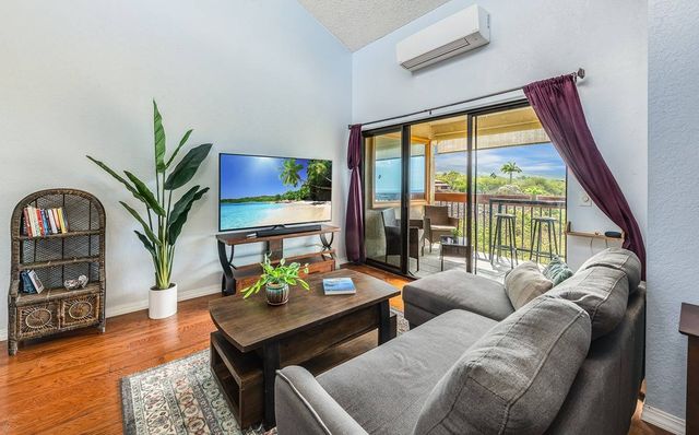 a living room with furniture large window and wooden floor
