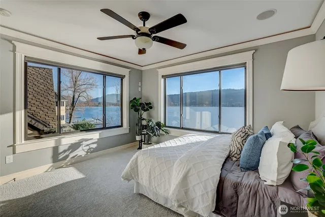 a bedroom with a bed and large windows with outer view