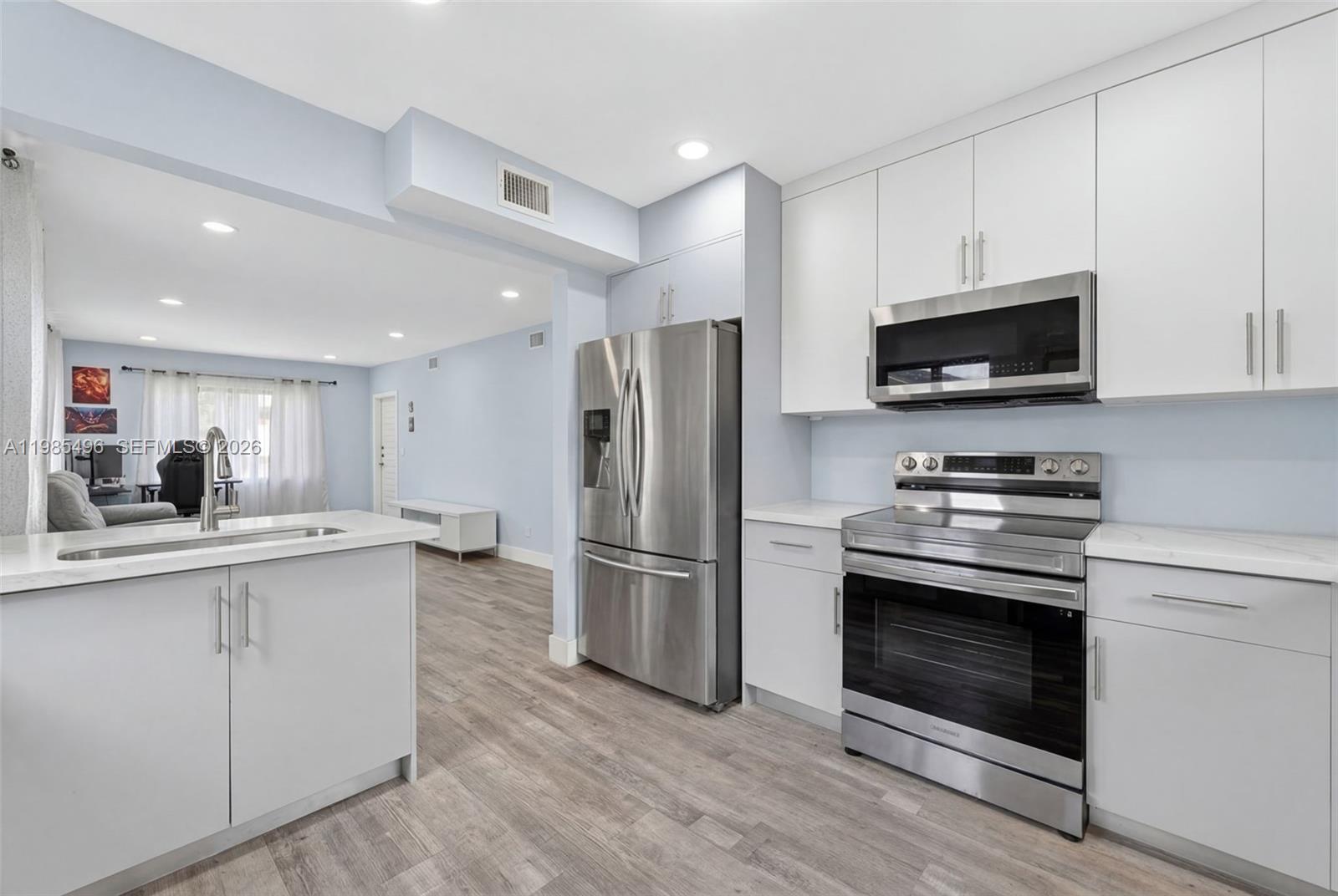 440 East 37th Street Hialeah, FL 33013 - Photo 8 of 27 a kitchen with stainless steel appliances a stove a sink and a microwave