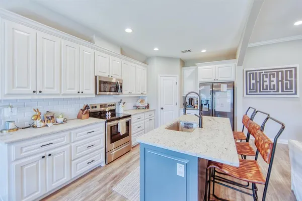 a kitchen with stainless steel appliances granite countertop a stove a sink dishwasher and a refrigerator with wooden cabinets