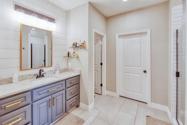 a spacious bathroom with a granite countertop sink and a mirror