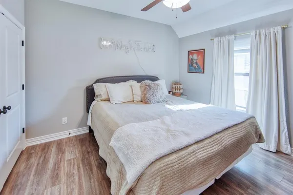 a large bed sitting in a bedroom next to a window and a chandelier