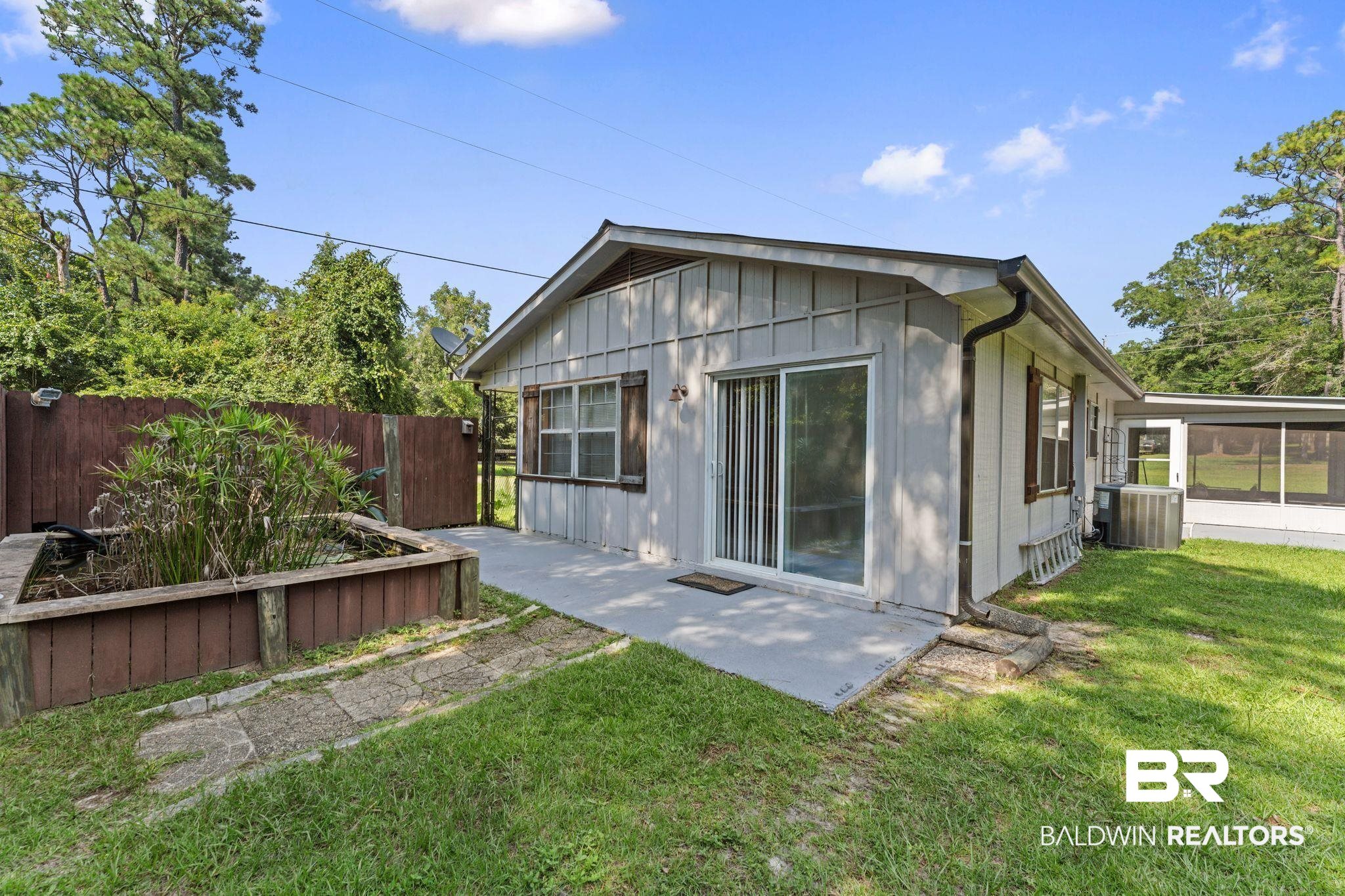 14095 Riverside Drive Foley, AL 36535 - Photo 23 of 30 Rear view of house with board and batten siding, a patio, and a sunroom